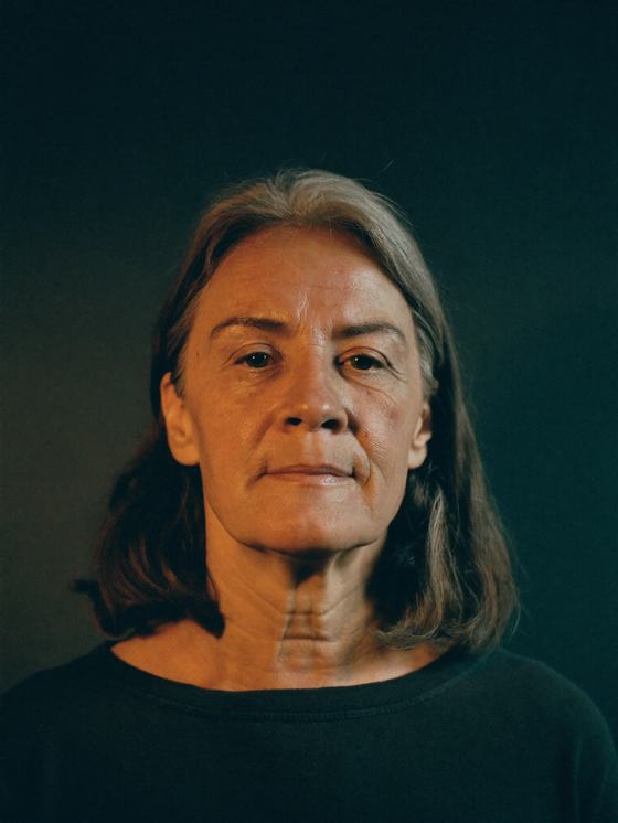 Mulher branca de 47 anos com expressão contida