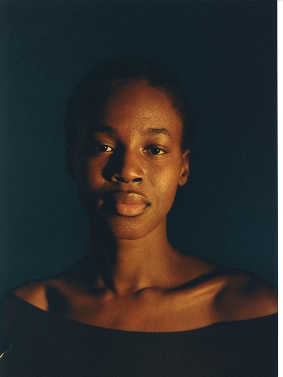 Mulher negra de 32 anos com expressão serena